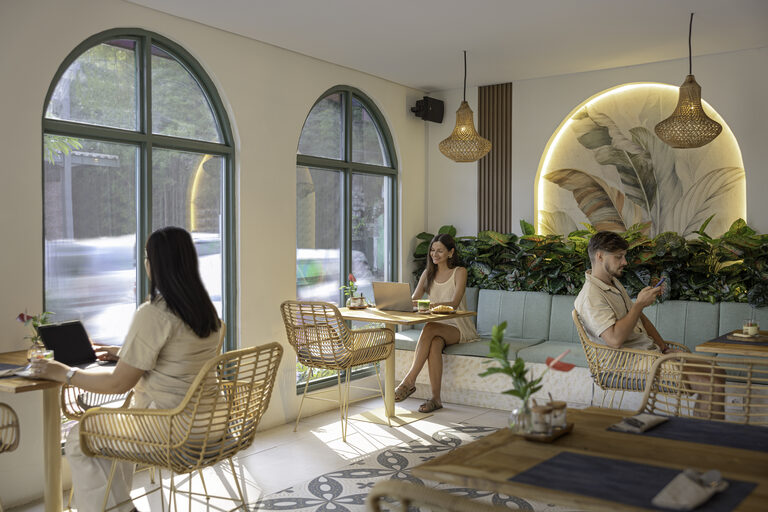 Guests working over coffee and pastries on the sage banquette.