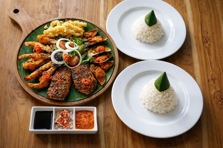 Overhead view of the seafood platter with two plates of steamed rice, laid for two people.