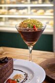 Dark chocolate mousse in a stemmed glass, crowned with a lacy sesame caramel tuile and chopped hazelnuts.