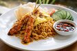 Mie goreng with shredded omelette and fried shallots, served with chicken satay, prawn crackers and sambal.
