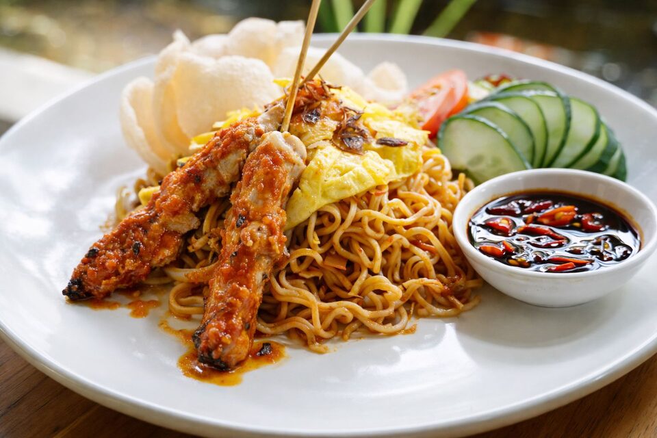 Mie goreng with shredded omelette and fried shallots, served with chicken satay, prawn crackers and sambal.